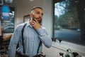 Bearded man on a blurred background. Handsome man touching new beard in a barbershop. Hipster style concept. Copy space.