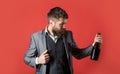 Bearded man with a bottle champagne of and glass. The person holds a red wine bottle in a hand. Man holding bottle with Royalty Free Stock Photo