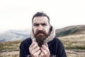 Bearded man, brutal caucasian hipster with moustache cold on mountain