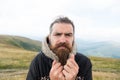 Bearded man, brutal caucasian hipster with moustache cold on mountain