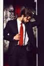 Bearded man, businessman in suit and red tie against wallpaper