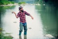 Bearded man catching fish. Summer leisure. Mature man fishing on the pond. Portrait of cheerful senior man fishing. Male