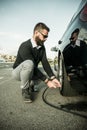 Bearded man checking tire pressure Royalty Free Stock Photo