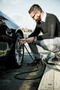 Bearded man checking tire pressure Royalty Free Stock Photo