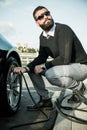 Bearded man checking tire pressure Royalty Free Stock Photo