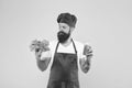 Bearded man chef in apron and hat. hipster decide what to choose. healthy eating and dieting concept. cook hold fresh Royalty Free Stock Photo