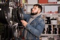 Bearded man chooses frying pans for his kitchen Royalty Free Stock Photo