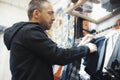 Bearded man chooses T-shirts at the shop. Royalty Free Stock Photo