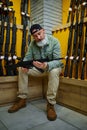 Bearded man choosing automatic rifle in gun store