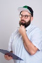 Bearded man with clipboard and baseball cap