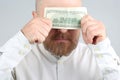 Bearded man closes a dollar bill with his face