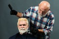 Bearded man coloring hair. Hair salon, hair coloring man. Attractive senior barber doing a haircut and haircolor for Royalty Free Stock Photo