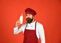 Bearded man cooking on red background. Mature chef or cook Royalty Free Stock Photo