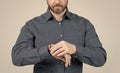 Bearded man cropped view in casual shirt check time on watch grey background, timekeeping