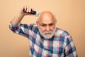 Bearded man cutting his own hair with a clipper. Middle aged bald man hair clipper, Mature baldness and hair loss Royalty Free Stock Photo
