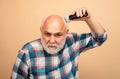 Bearded man cutting his own hair with a clipper. Middle aged bald man hair clipper, Mature baldness and hair loss Royalty Free Stock Photo
