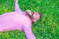 Bearded man with daisy flowers in beard lay on meadow, grass background. Hipster with bouquet of daisies in beard Royalty Free Stock Photo