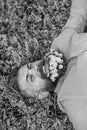 Bearded man with daisy flowers lay on grassplot, grass background. Hipster with bouquet of daisies in beard relaxing Royalty Free Stock Photo