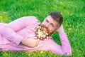 Bearded man with daisy flowers lay on meadow, lean on hand, grass background. Masculinity concept. Hipster with daisies Royalty Free Stock Photo