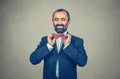 Bearded man with dark suit,  blue shirt, adjusting red butterfly bow, tie Royalty Free Stock Photo