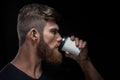 Bearded man drinking coffee on the go