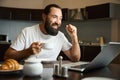Bearded man drinks coffee and communicates emotionally online Royalty Free Stock Photo