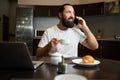 Bearded man drinks coffee and communicates emotionally on the phone Royalty Free Stock Photo