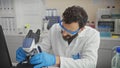 Bearded man examining samples using a microscope in a laboratory setting Royalty Free Stock Photo