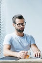 bearded man in eyeglasses holding glass of whiskey and working Royalty Free Stock Photo