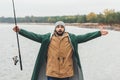 bearded man with fishing rod showing size of fish