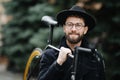 Bearded man with fixie bicycle. Low angle view of confident young bearded man carrying his bicycle on shoulder and looking away