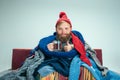 Bearded Man with Flue Sitting on Sofa at Home. Healthcare Concepts.