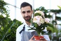 Bearded Man Gardener Holding White Flower in Pot