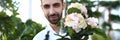 Bearded Man Gardener Holding White Flower in Pot