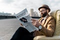 bearded man in glasses reading business newspaper in armchair Royalty Free Stock Photo