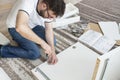 Bearded man in glasses, a white T-shirt and jeans sits on a carpet in the living room and twists furniture. He holds a screwdriv Royalty Free Stock Photo