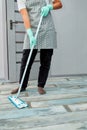 Bearded man in gloves with mop in hand cleaning floor in the house Royalty Free Stock Photo