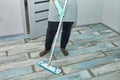 Bearded man in gloves with mop in hand cleaning floor in the house Royalty Free Stock Photo