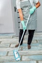 Bearded man in gloves with mop in hand cleaning floor in the house Royalty Free Stock Photo