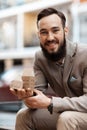 The bearded man is happy. The businessman opened a building firm. A model poses.for an advertisement for a real estate company