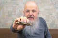 bearded man with a harmonica in his hand. music and hobbies Royalty Free Stock Photo