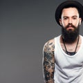 Bearded Man in Hat. hipster boy with tattoo Royalty Free Stock Photo