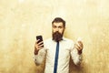 Bearded man or hipster compare mobile phone and smartphone Royalty Free Stock Photo