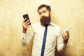 Bearded man or hipster compare mobile phone and smartphone Royalty Free Stock Photo