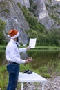 bearded man, hipster in a white shirt and santa hat holds a blank sheet of paper in hand. Reads a speech