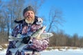 Bearded man is holding frozen fish after successful winter fishing at cold sunny day Royalty Free Stock Photo