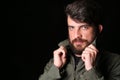 Bearded man holding his collar. Close.up. Black