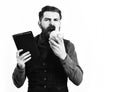 Bearded man holding notepad and moneybox with serious face