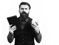 Bearded man holding notepad and moneybox with serious face