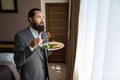 Bearded man holds a plate of food in his hands